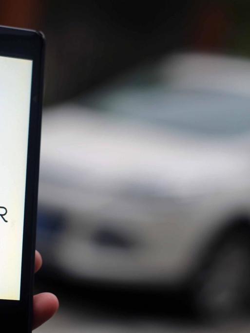 Ein Mann in Shanghai nutzt die Taxi-App Uber.
