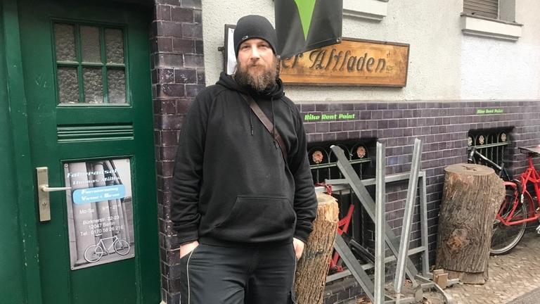 Der Besitzer des Fahrradladens in Berlin vor seiner Tür.