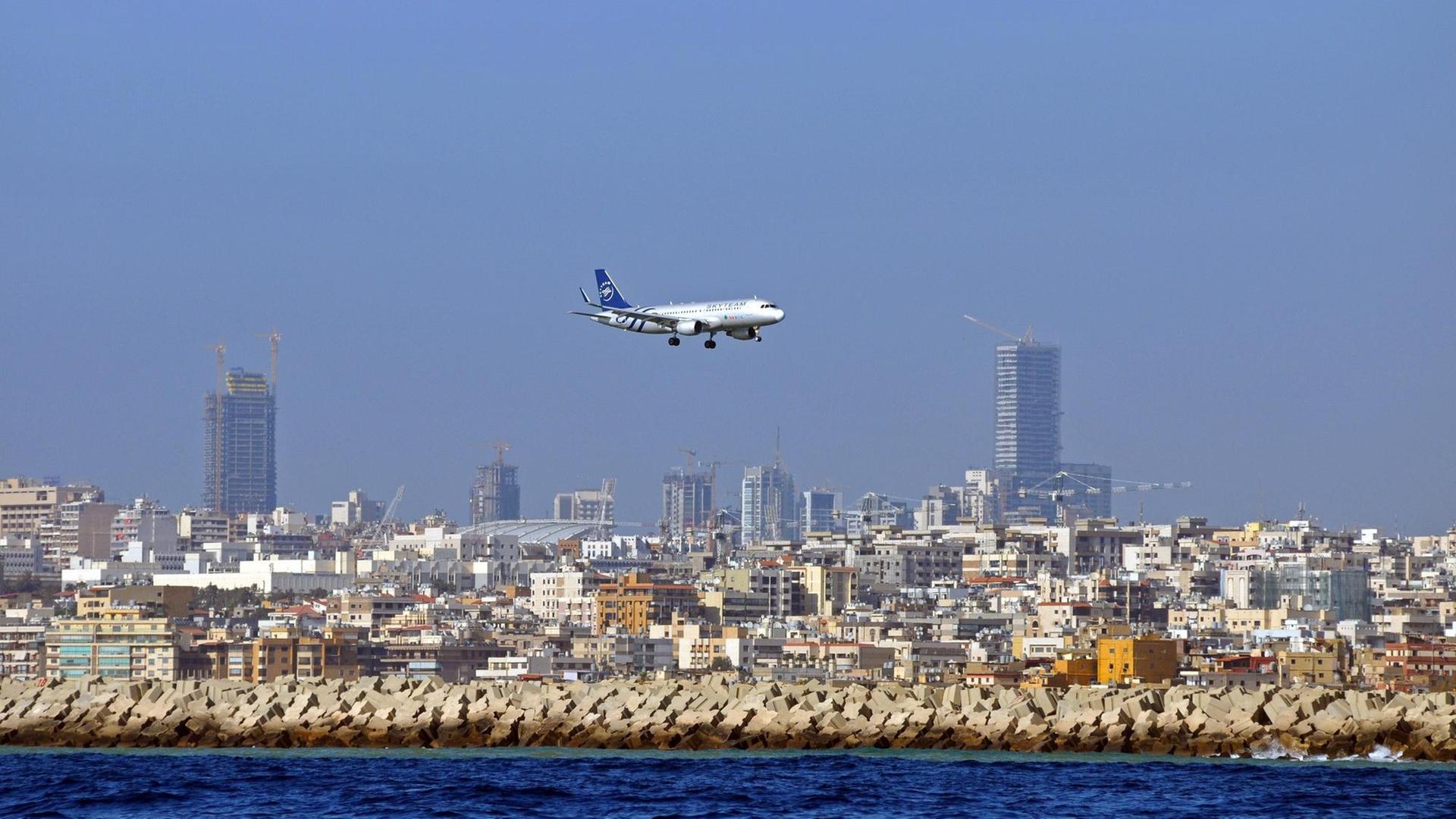 Man sieht ein Flugzeug und dahinter die Hochhäuser der Stadt Beirut.