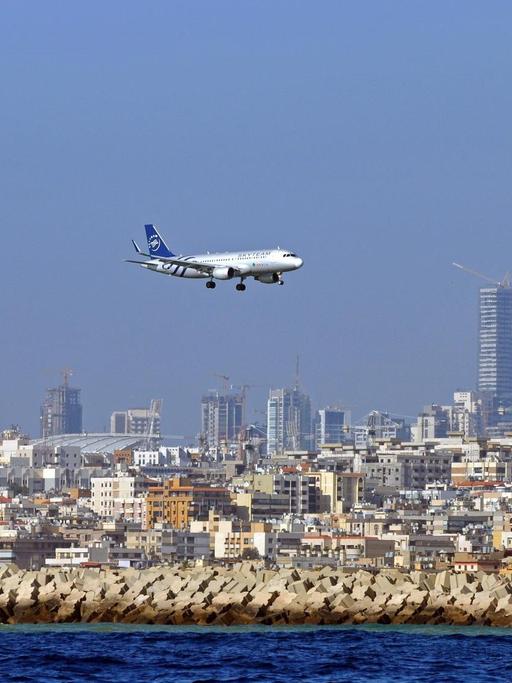 Man sieht ein Flugzeug und dahinter die Hochhäuser der Stadt Beirut.