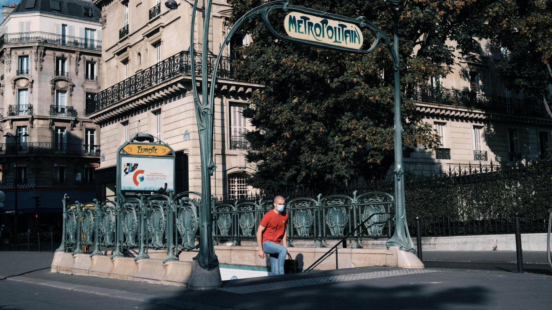 Ein Mann mit Nasen-Schutz-Maske kommt aus einer Metro-Station in Paris.