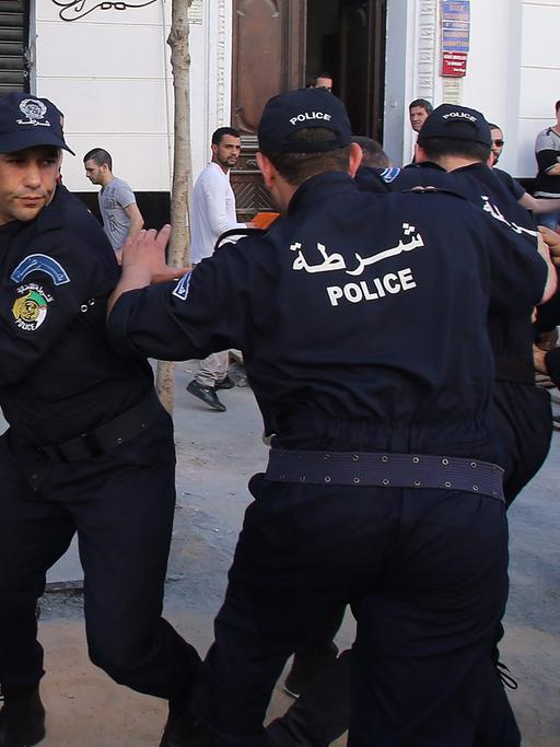 Algerische Polizisten zerschlagen eine Protestveranstaltung im Rahmen der Präsidentschaftswahl.