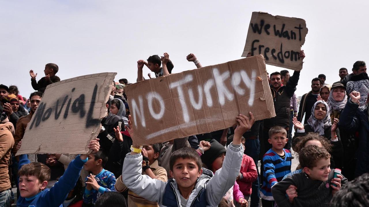 Flüchtlinge auf der griechischen Insel Chios halten Schilder hoch mit Sprüchen wie: "Nicht Türkei" oder "Wir wollen Freiheit/Frieden".