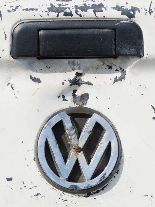 Ein beschädigtes VW Logo hängt am zerkratzten Kofferraum eines Volkswagen in Wolfsburg.