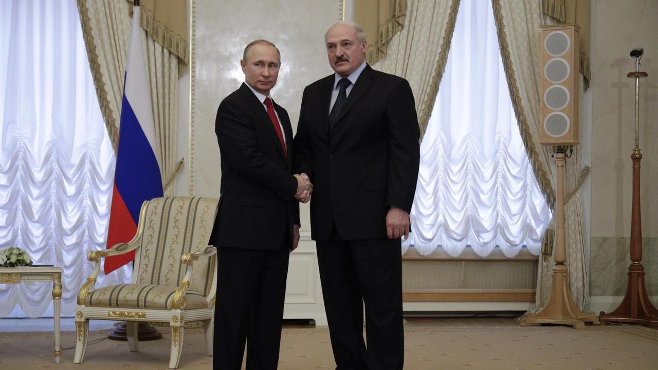 Das Bild zeigt den russischen Präsidenten Wladimir Putin am 03.04.2017 bei einem Treffen in St. Petersburg (Russland) neben dem weißrussischen Präsidenten Alexander Lukaschenko. Beide schauen in die Kamera und geben sich die Hand.