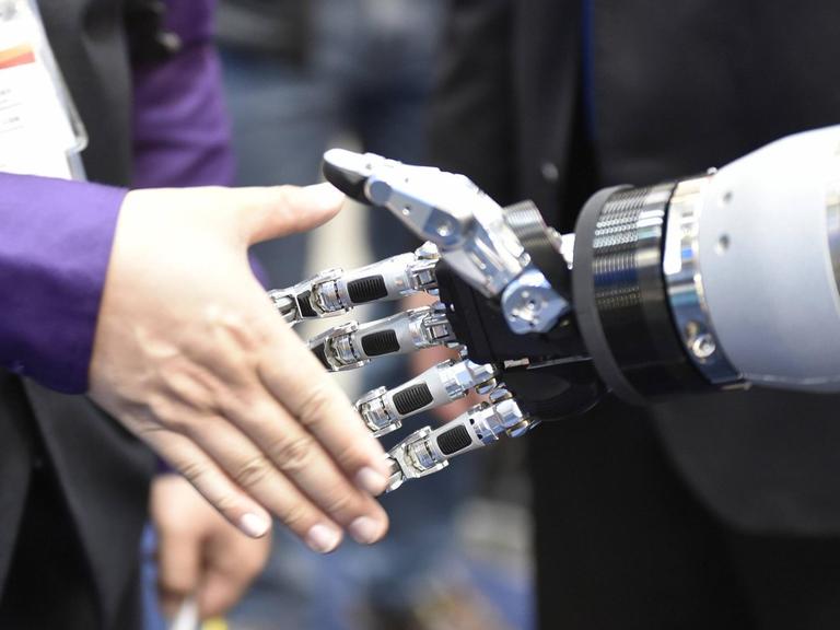 Menschenhand in Roboterhand am 24.04.2017 auf der Industriemesse in Hannover.