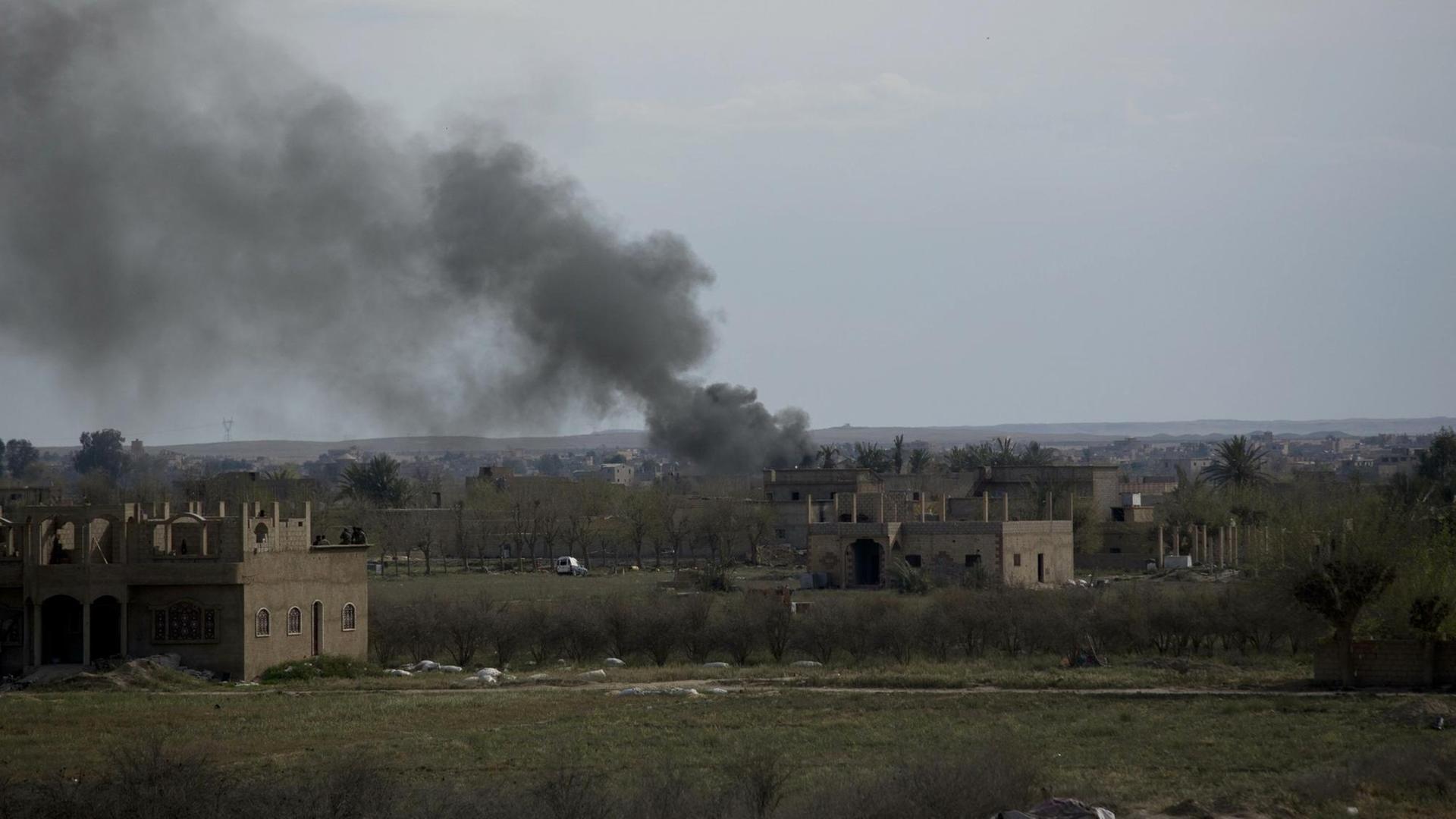 Rauch steigt über der Stadt Baghus in Syrien auf.