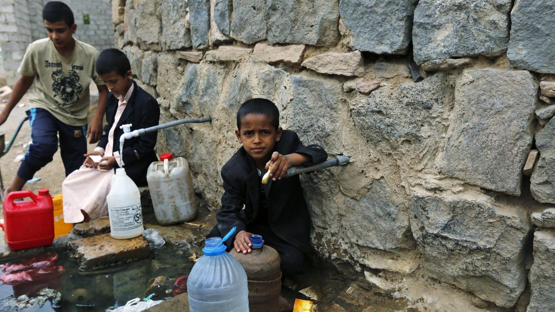 Kinder im Jemen füllen Kanister mit Wasser in der Hauptstadt Sanaa.