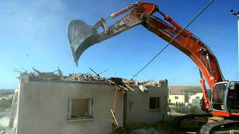 21.8.2005: Nach dem Abzug der Siedler lassen die israelischen Behörden die Siedlungsgebäude in Peat Sadeh, Gush Katif, Gazastreifen, abreißen. Das Bild zeigt einen Bagger, der ein Haus einreißt.