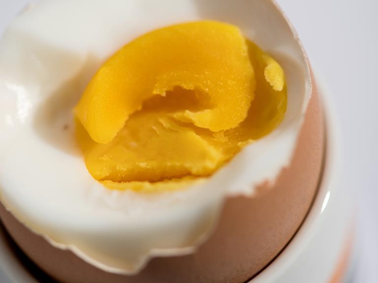 Ein hartgekochtes Ei steht auf einem Tisch.