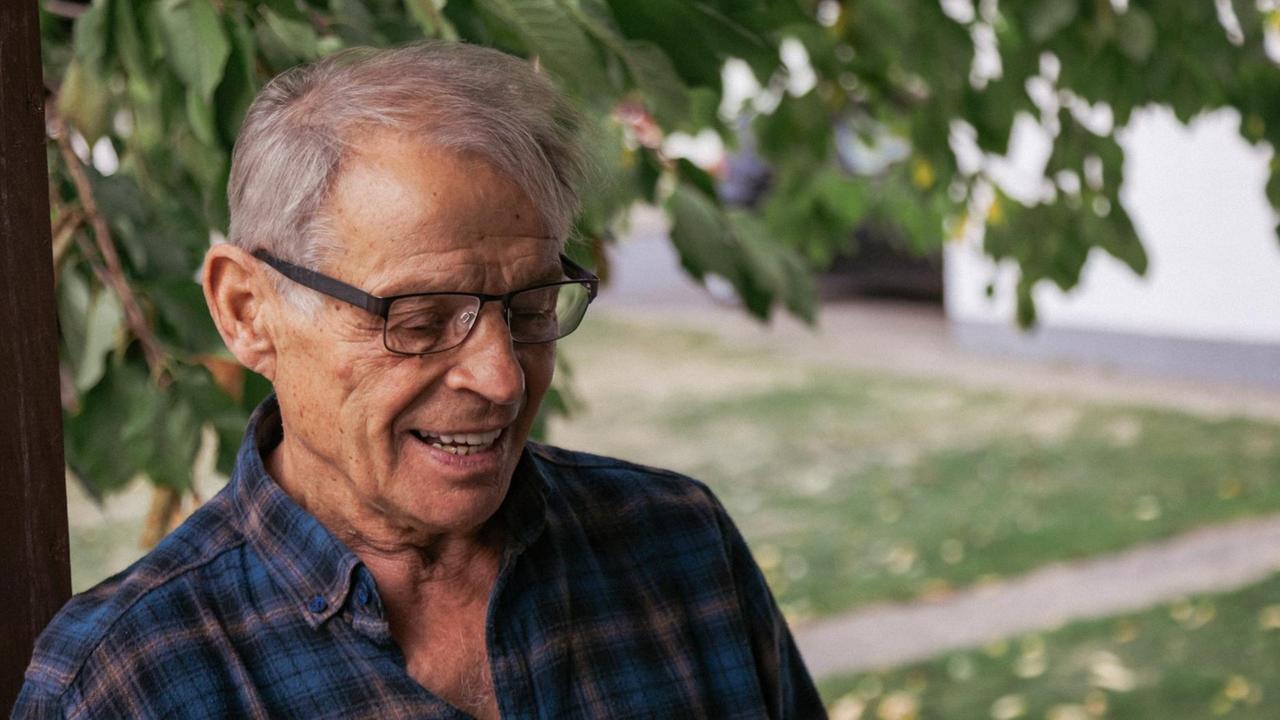 Roland Wenzel steht im Garten und trägt Hemd und Brille.