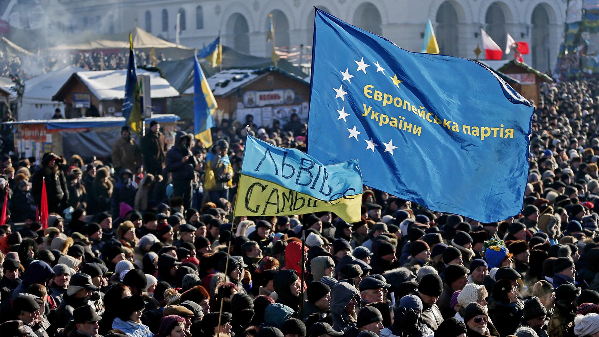 Menschen mit Ukraine- und EU-Flaggen auf dem Maidan in Kiew.