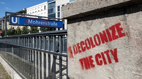 30.07.2020, Berlin: Vor dem Eingang der U-Bahnstation Mohrenstraße hat jemand mit roter Farbe "decolonize the city" an die Wand geschrieben.