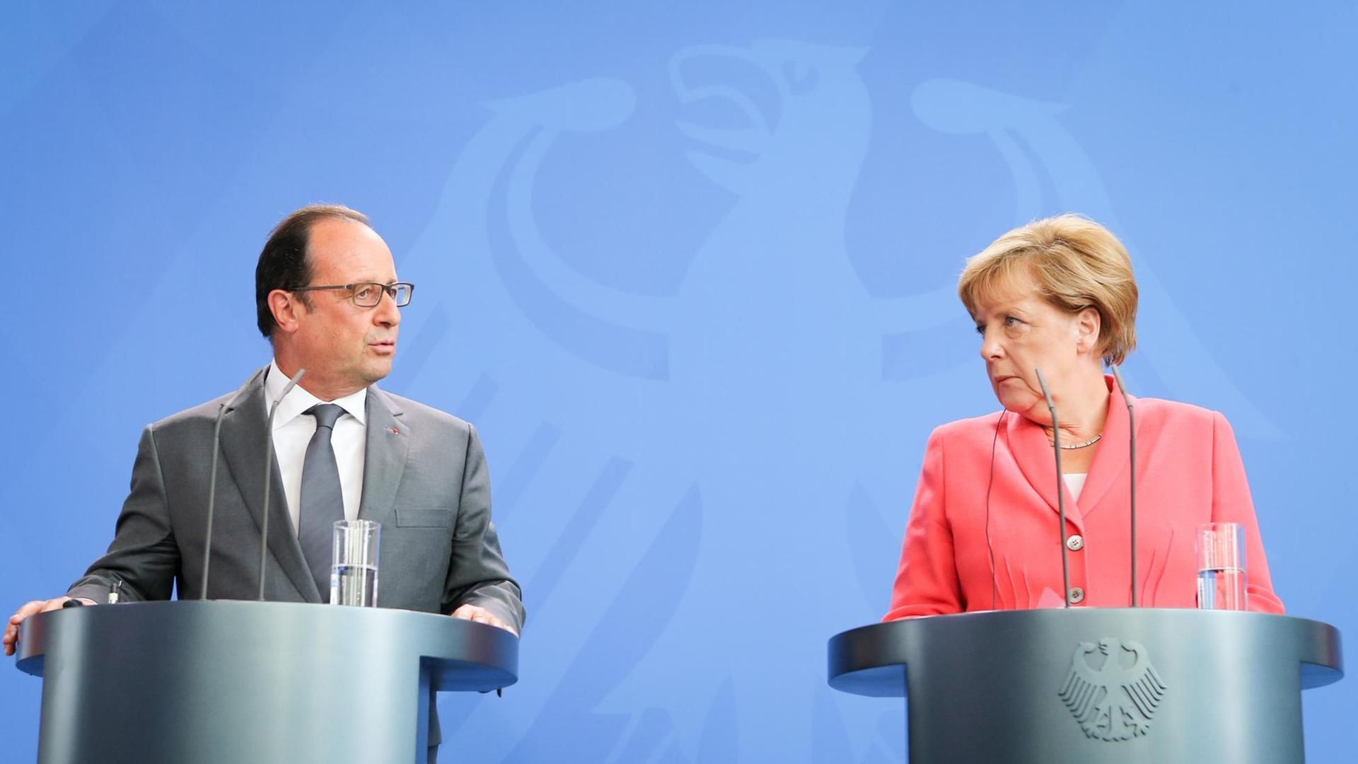 Bundeskanzlerin Angela Merkel (CDU) und Frankreichs Präsident Francois Hollande sprechen am 24.08.2015 in Berlin im Bundeskanzleramt vor einem Treffen zu den Medienvertretern.