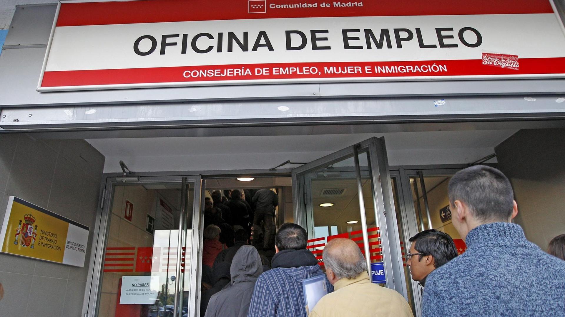 Erwerbslose stehen vor einem Arbeitsamt in Madrid Schlange.