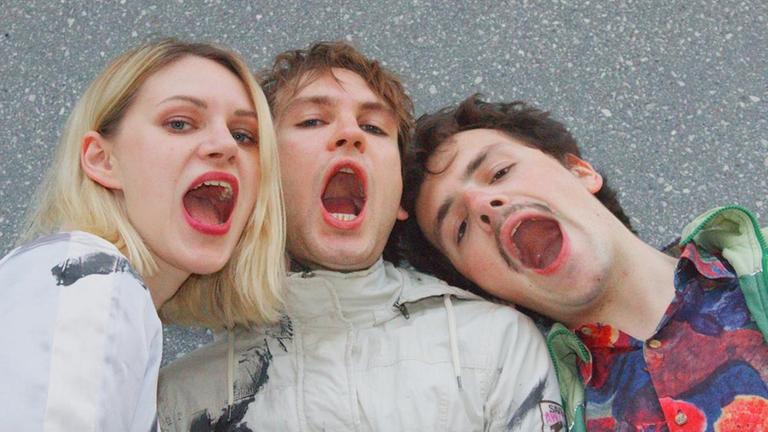 Pauls Jets - das sind Bassistin Romy Park, Sänger Paul Buschnegg und Drummer Xavier Plus. Auf diesem Bild posieren sie mit offenen Mündern