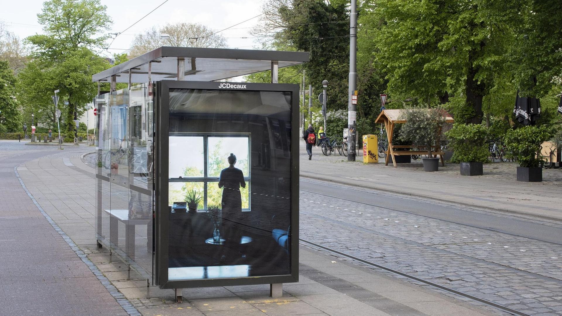 "Based on Truth" von Björn Behrens: Ein Foto einer Wartehalle der Bahn in Bremen mit dem Motiv einer Frau, die aus dem Fenster schaut