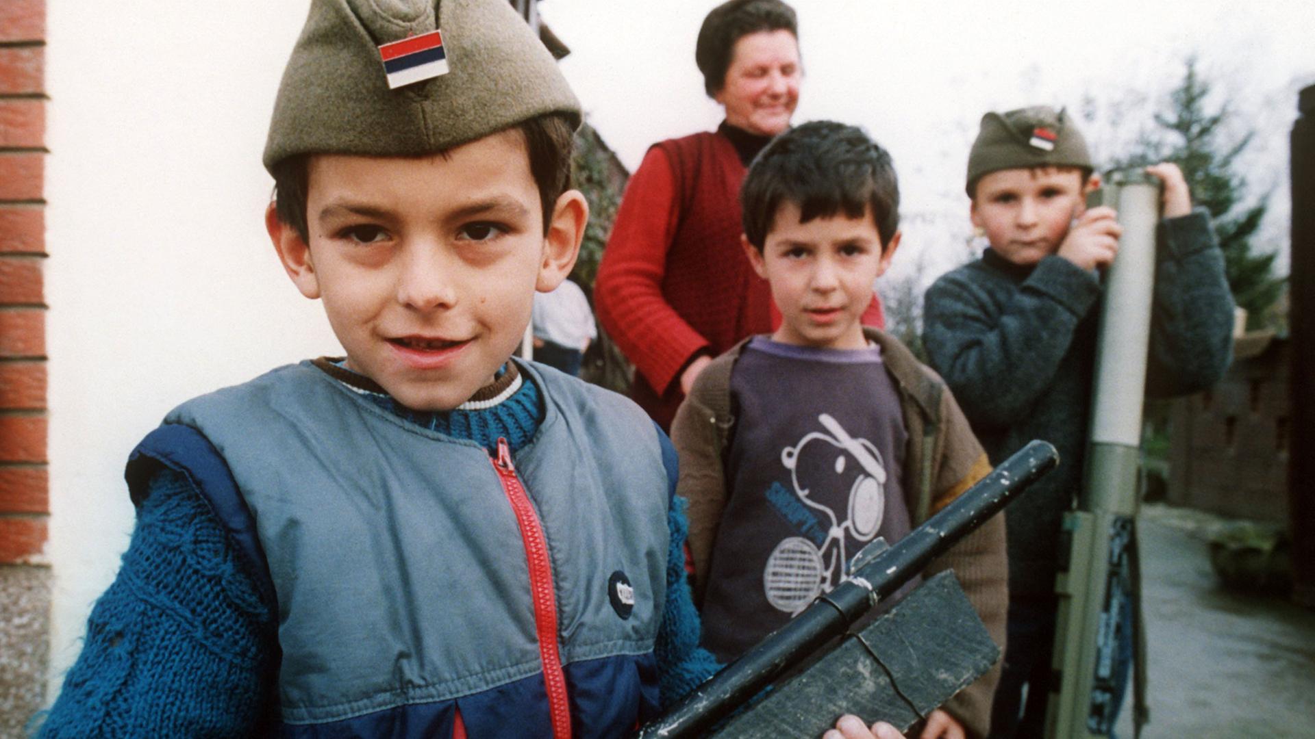 Kinder ahmen während des jugoslawischen Bürgerkriegs mit selbstgebastelten Waffen den Krieg der Erwachsenen nach.