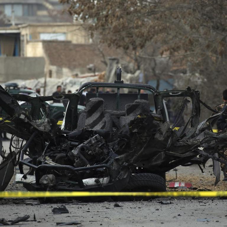 Afghan security personnel remove a damaged vehicle from the site of a bomb attack in Kabul, Afghanistan, Saturday, Feb. 20, 2021. Three separate explosions in the capital Kabul on Saturday killed and wounded multiple people, an Afghan official said. (AP Photo)
