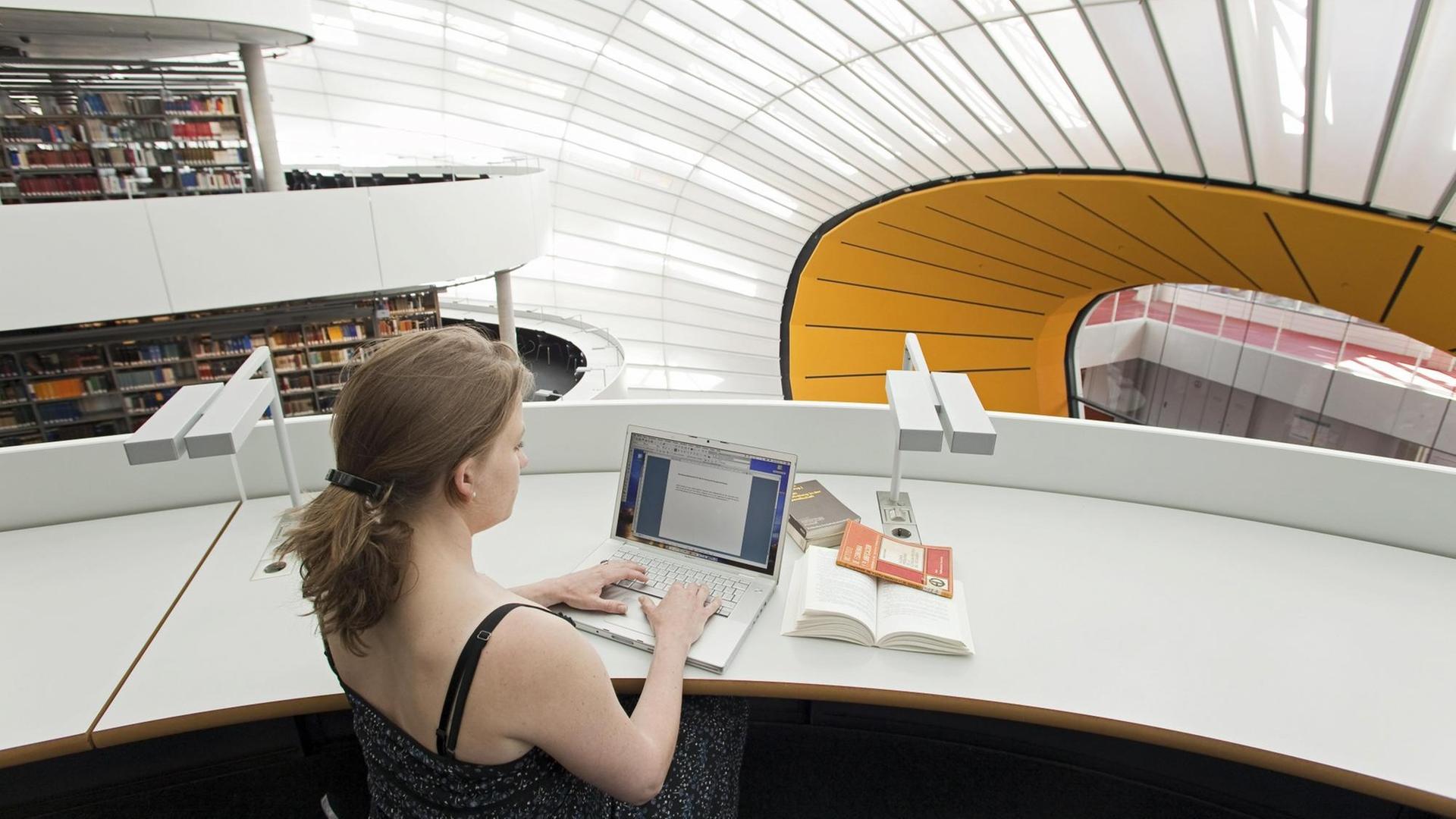 Studentin bei der Arbeit in der Neuen Philologischen Bibliothek der Freien Universität, Berlin, entworfen von Norman Foster.