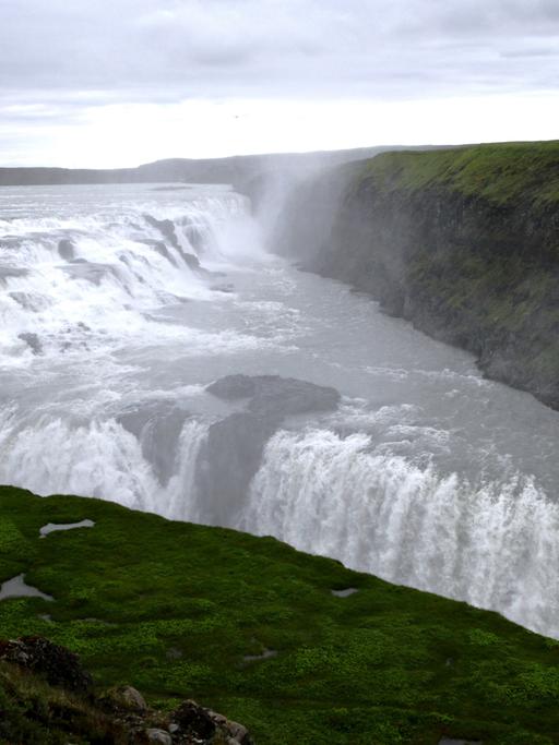 Der Wasserfall Gullfoss fließt in Haukadalur, Island. Der Wasserfall zählt zu den beeindruckensten seiner Art auf Island und liegt auf der beliebten Touristenroute "Goldener Kreis", auf deren Strecke auch die Stadt Geysir und der Nationalpark Þingvellir liegen.