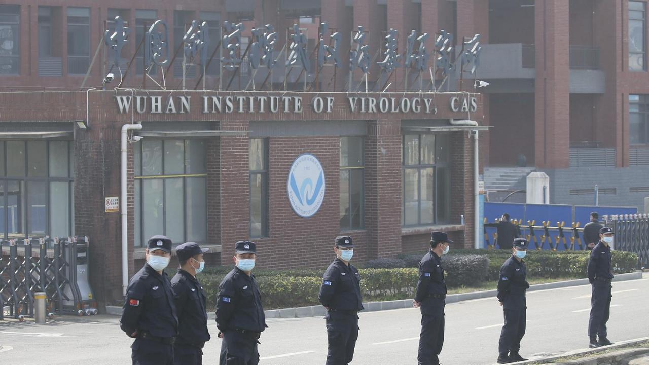 Vor dem virologischen Institut in Wuhan in China stehen Männer in Uniform und mit Mundschutz.