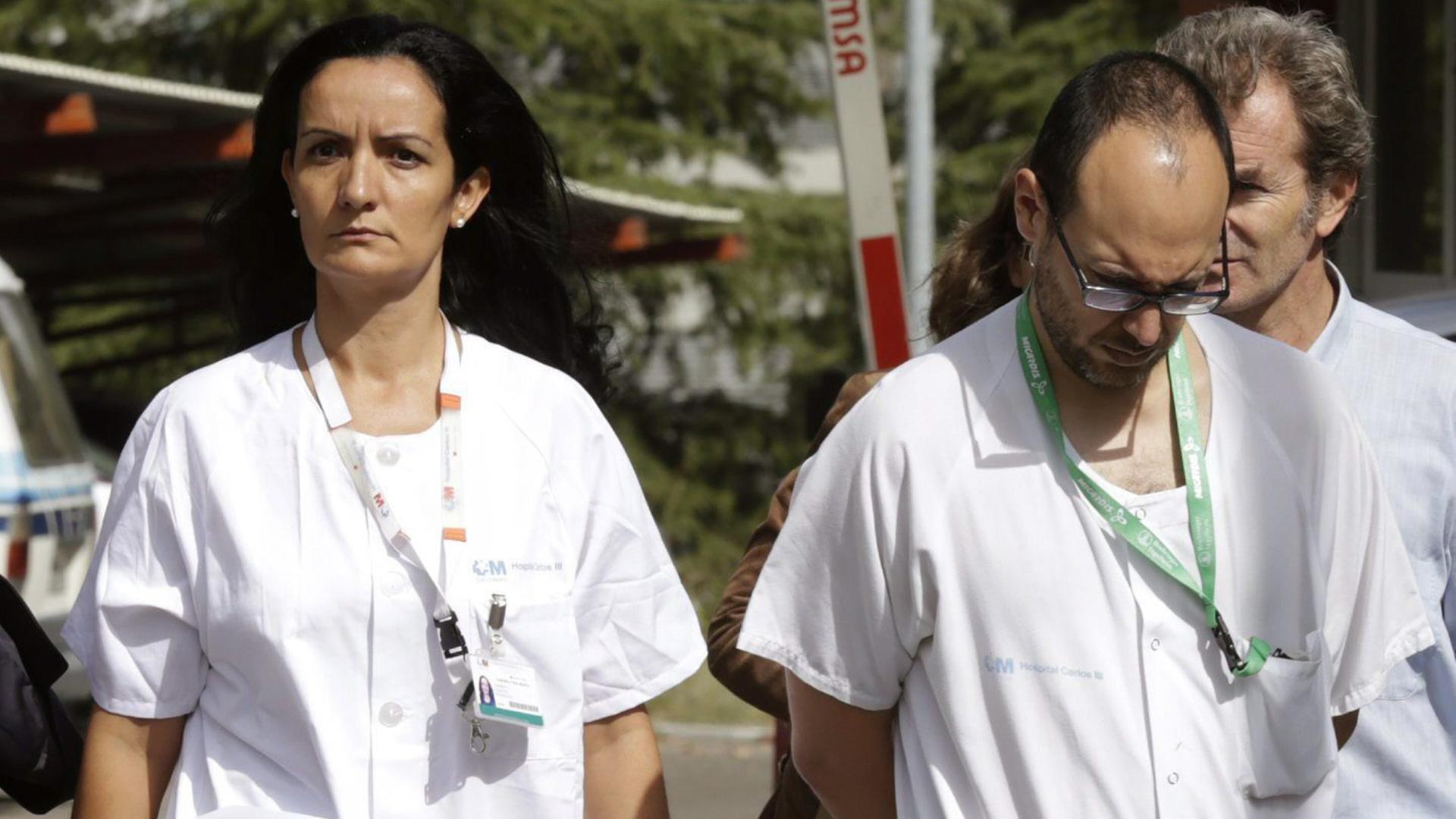 Drei Ärzte in weißen Kitteln vor dem Madrider Krankenhaus