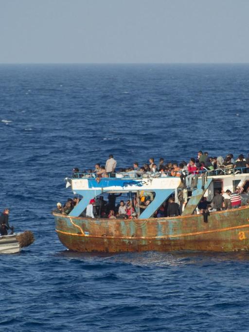 Die französische Marine begleitet ein Flüchtlingsboot im Mittelmeer zwischen Malta und Süditalien.