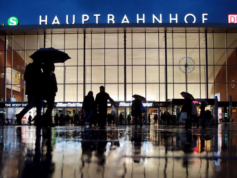 Zu sehen ist der Kölner Hauptbahnhof abends im Regen.