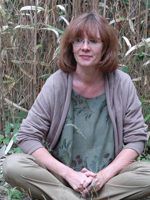Die Schriftstellerin Patricia Görg sitzt in der Natur.