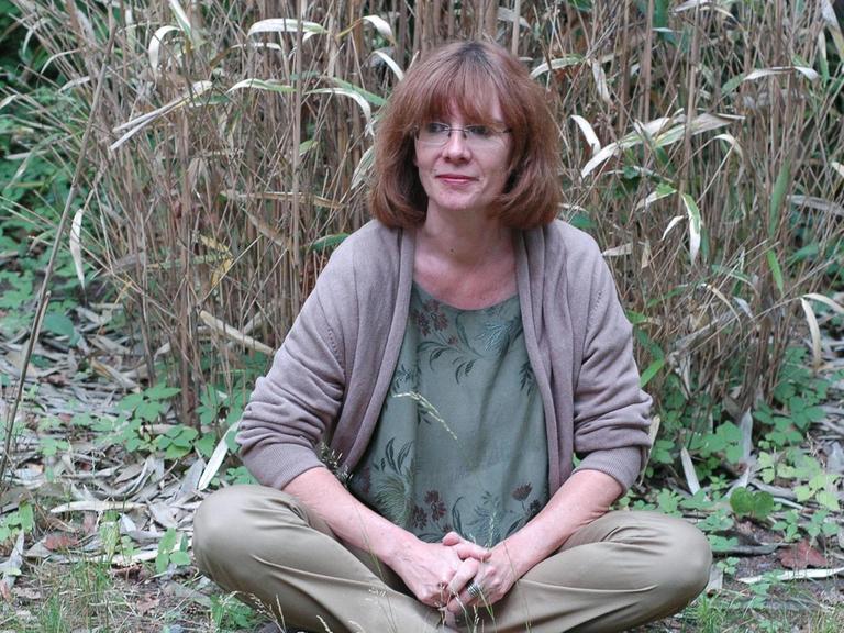 Die Schriftstellerin Patricia Görg sitzt in der Natur.