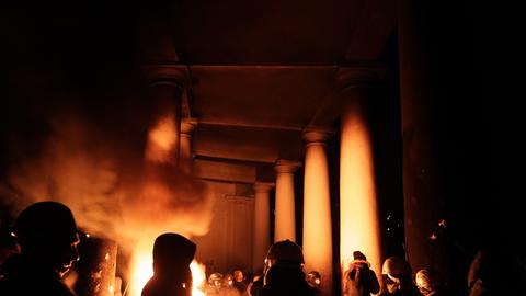 Demonstranten in Kiew wärmen sich an einem Feuer in der Nacht