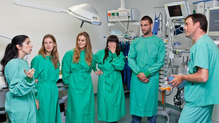Fünf spanische Pflegekräfte sprechen mit dem Stationsleiter vom Pflegedienst im Universitätsklinikum Erlangen.
