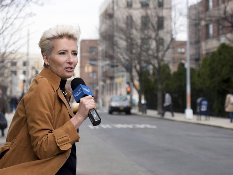 Eine Reporterin steht vor einer leeren Straße und spricht ins Mikrofon