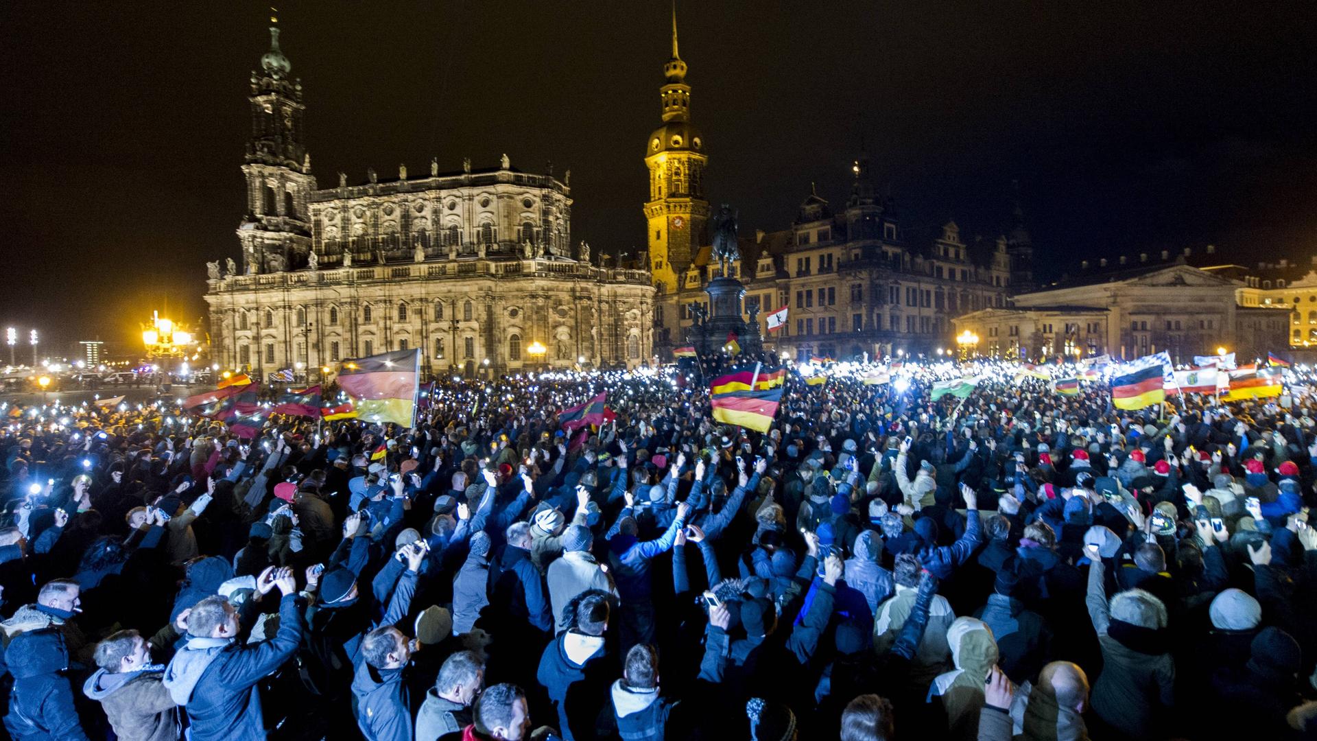 Teilnehmer einer Demonstration des Bündnisses "Patriotischer Europäer gegen die Islamisierung des Abendlandes" (Pegida) sind am Montagabend (22.12.14) auf dem Theaterplatz in Dresden versammelt.