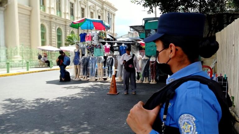 Eine Polizistin bewacht einen Platz mit Marktständen im Zentrum San Salvadors.