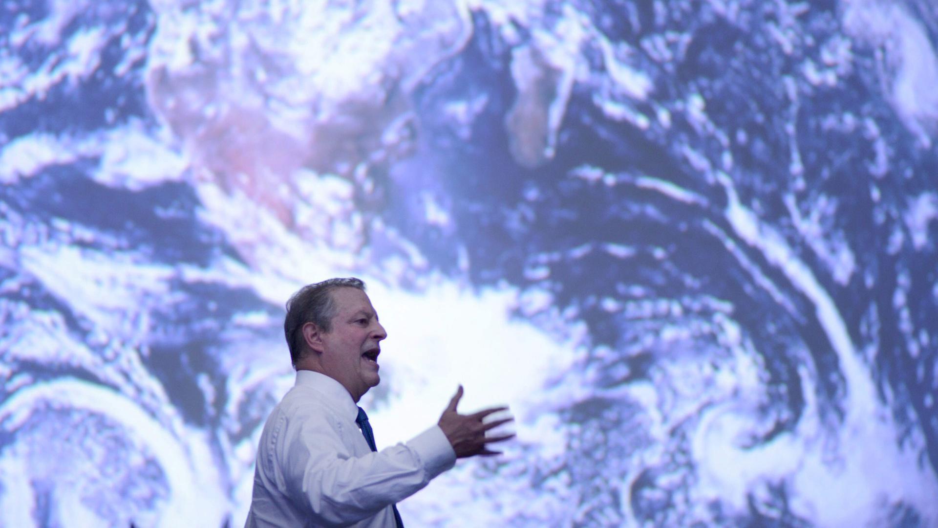 Al Gore spricht auf der Klima-Konferenz vor einem riesigen Satellitenbild der Erde.