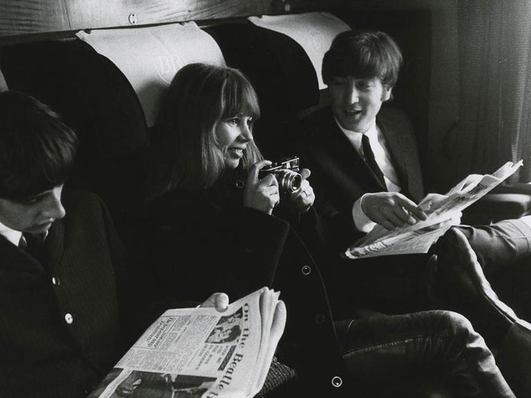 Astrid Kirchherr (mit Kamera) und die Beatles sitzen im Zug während des Films "A Hard Day's Night", ca. 1960.