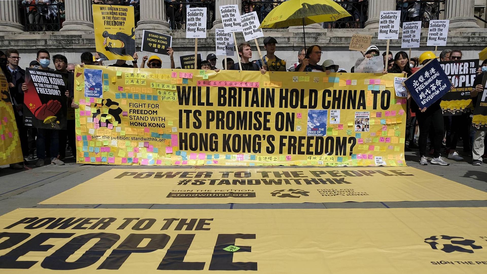 Demonstration in London am 17. August 2019 für Demokratie und Gerechtigkeit in Hongkong. Demonstranten halten Spruchbänder mit der Aufschrift "WILL BRITAIN HOLD CHINA TO IT'S PROMISE ON HONG KONG'S FREEDOM?"