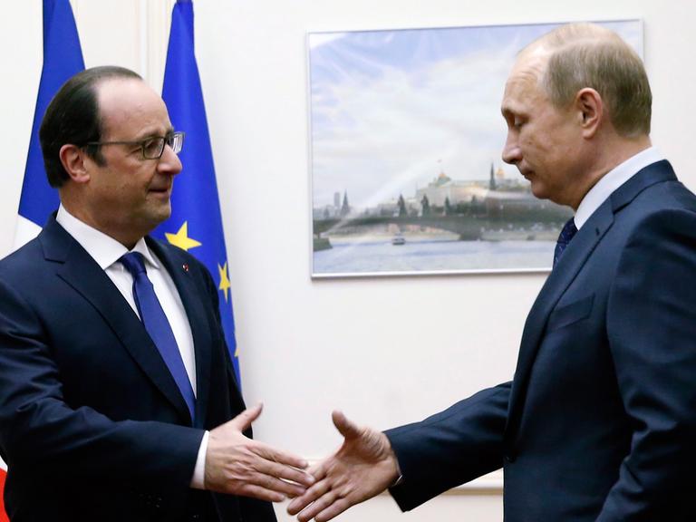 Frankreichs Präsident Francois Hollande und sein russischer Amtskollege Wladimir Putin geben sich die Hand.