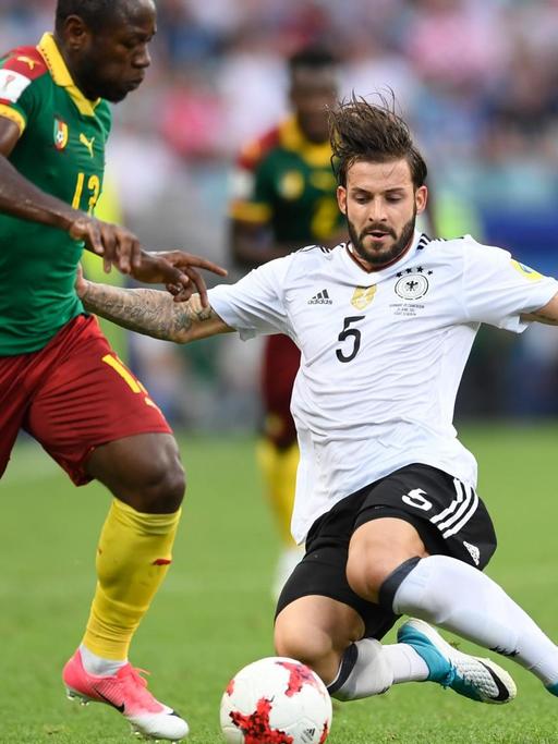 Der deutsche Fußballer Marvin Plattenhardt (r) und der kamerunische Spieler Christian Bassogog kämpfen beim Vorrundenspiel des Fußball-Confed-Cup zwischen Deutschland und Kamerun um den Ball.