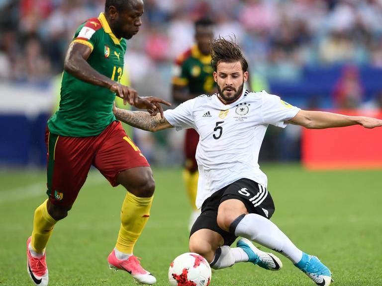 Der deutsche Fußballer Marvin Plattenhardt (r) und der kamerunische Spieler Christian Bassogog kämpfen beim Vorrundenspiel des Fußball-Confed-Cup zwischen Deutschland und Kamerun um den Ball.