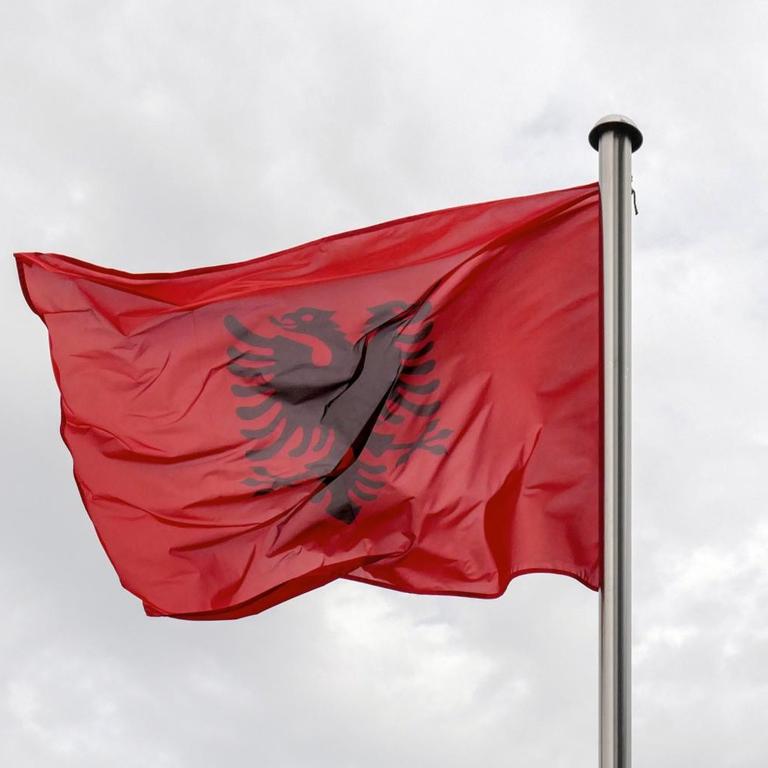 Symbolbild: die albanische Flagge und das EU-Banner im Wind
