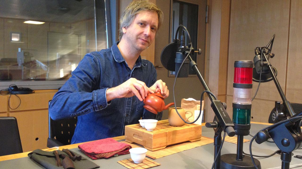 Der Teespezialist Jens de Gruyter gießt im im Studio von Deutschlandradio Kultur Tee in eine Kanne.