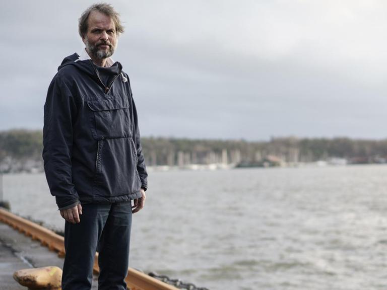 Erling Kagge steht am Oslofjord an einem Kai.