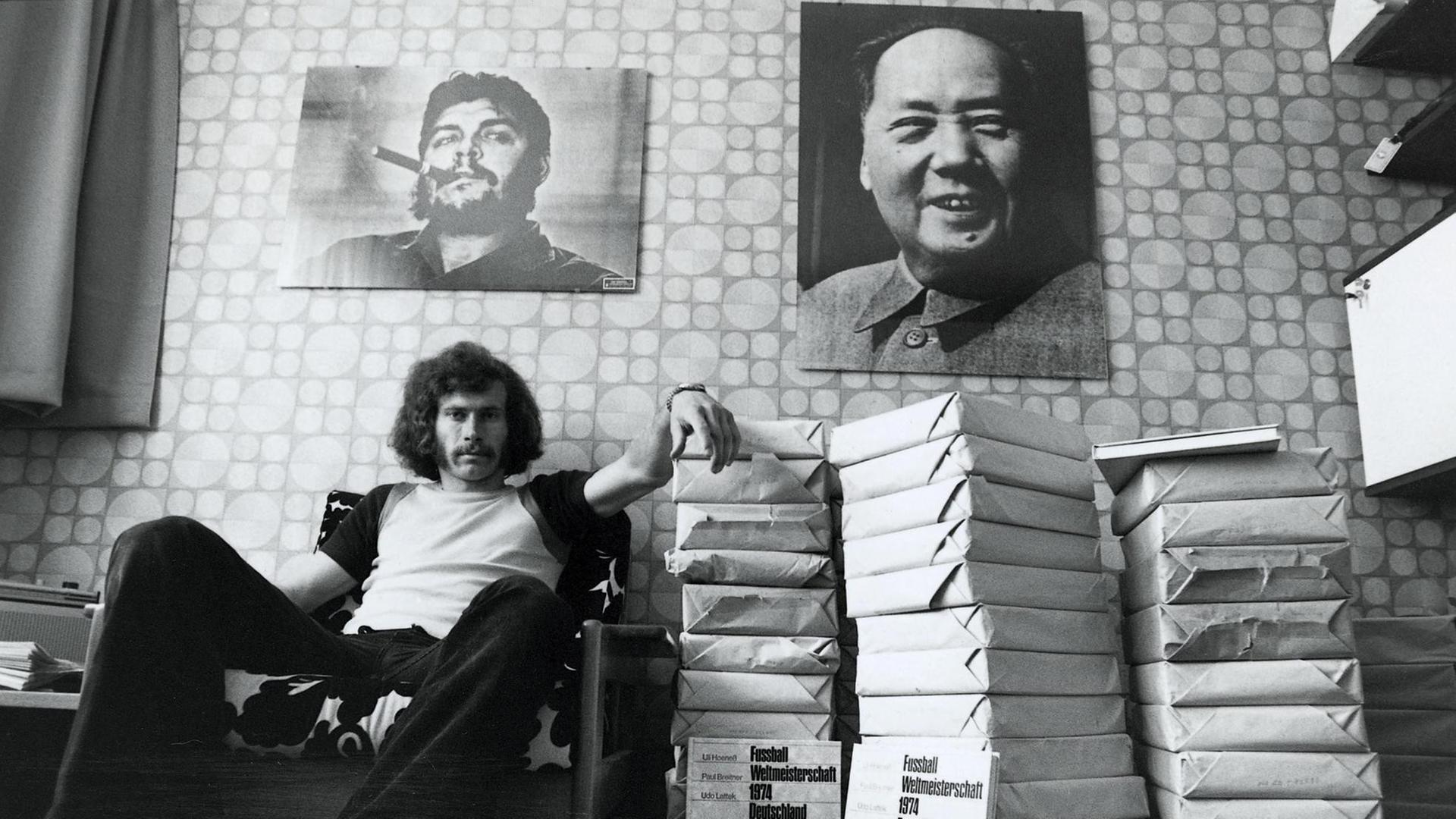 Paul Breitner sitzt nach der gewonnen WM 1974 in seinem Arbeitszimmer. Über ihm an der Wand hängt ein Bild von Che Guevara und eins von Mao Zedong.
