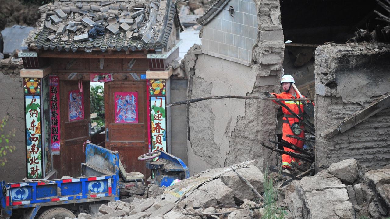 A Chinese rescuer searches in the debris of houses destroyed by the 6.6-magnitude earthquake in Yongxing village, Meichuan town, Minxian county, Dingxi city, northwest Chinas Gansu province, 23 July 2013. The death toll in the devastating earthquake in no A Chinese rescuer searches in the debris of houses destroyed by the 6.6-magnitude earthquake in Yongxing village, Meichuan town, Minxian county, Dingxi city, northwest Chinas Gansu province, 23 July 2013. The death toll in the devastating earthquake in no
