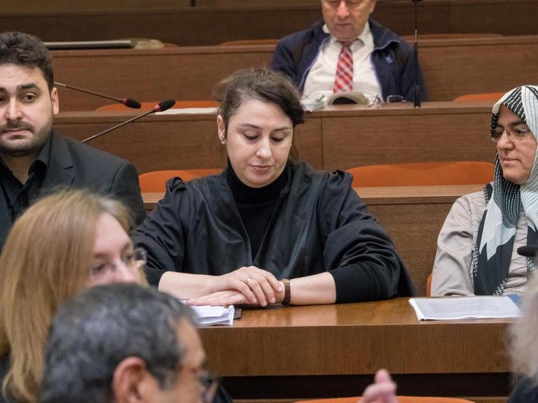 Die Nebenkläger Abdulkerim Simsek (l), Sohn des am 09.09.2000 in Nürnberg erschossenen Enver Simsek und die Schwiegermutter Adile Simsek (r) des Verstorbenen sitzen am 09.01.2018 im Oberlandesgericht in München (Bayern) im Gerichtssaal neben ihrer Anwältin Seda Basay-Yildiz (M).