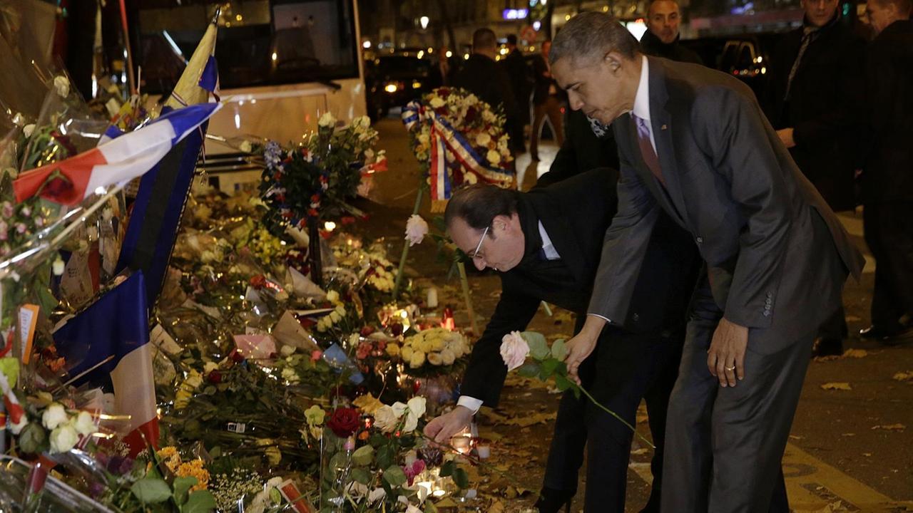 US-Präsident Barack Obama (re.) und Frankreichs Staatschef François Hollande legen Blumen vor der Konzerthalle Bataclan nieder