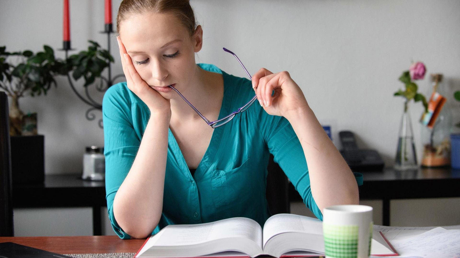 Eine Frau liest in einem sehr dicken Buch. Eine Frau liest in einem sehr dicken Buch.
